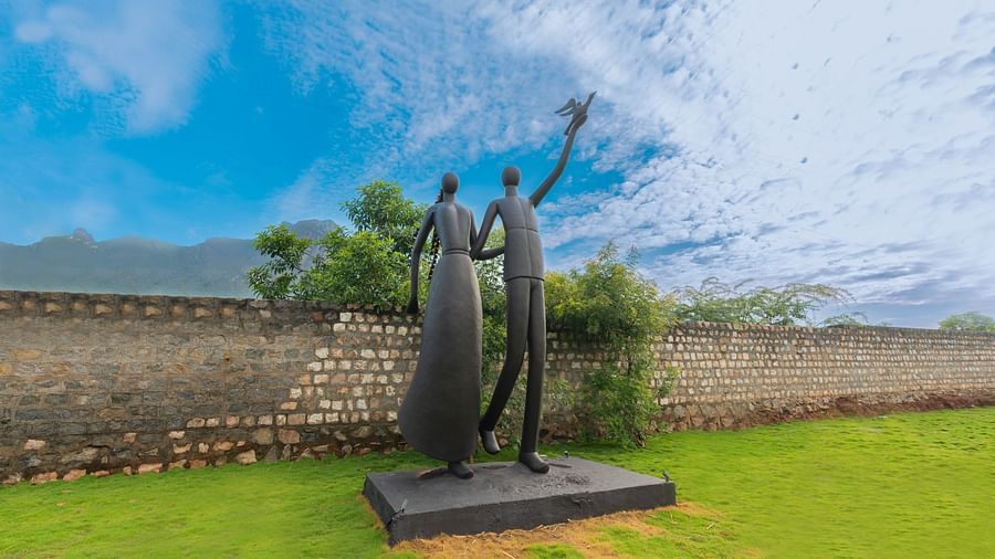 image of a grey coloured sculpture of a couple with a clear blue sky in the background - Darza Resorts