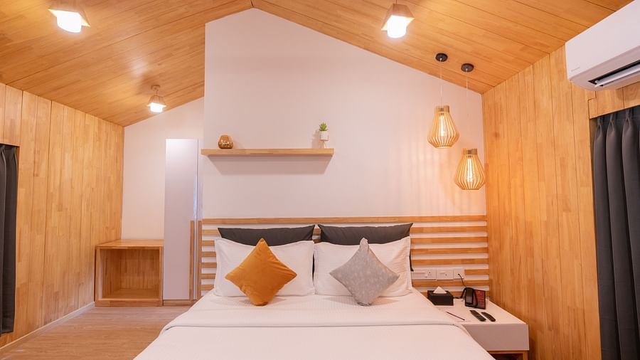 front view image of the premium room featuring a comfortable double bed with a bed side table besides it - Darza Resorts