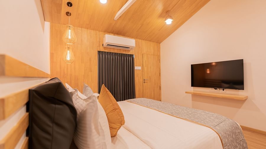 a close up image of the double bed at the premium room along with a wall mounted television - Darza Resorts