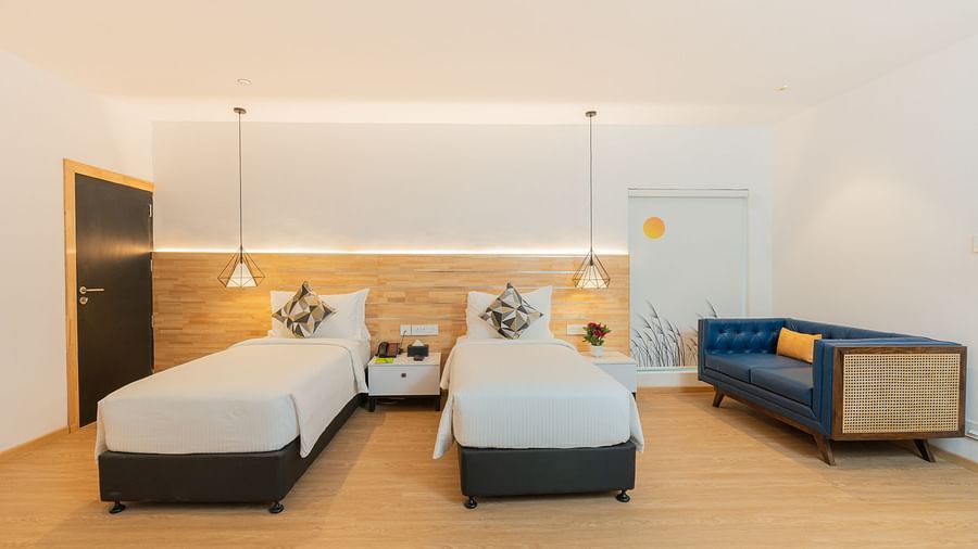 image of a garden room with a twin bed along with a teal coloured couch in the corner - Darza Resorts