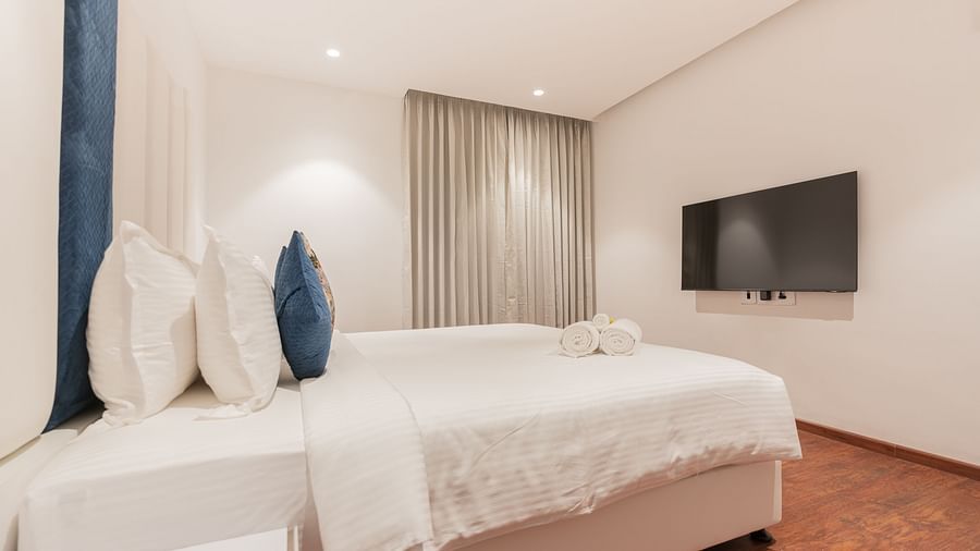 side view image of the double bed with a wall mounted television in a family villa two bedroom - Darza Resorts
