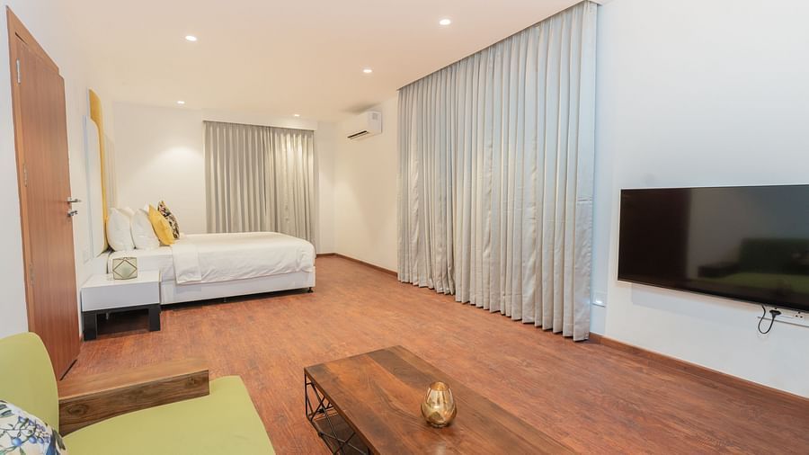 corner view image of the master bedroom featuring the couch and a double bed at the far corner - Darza Resorts