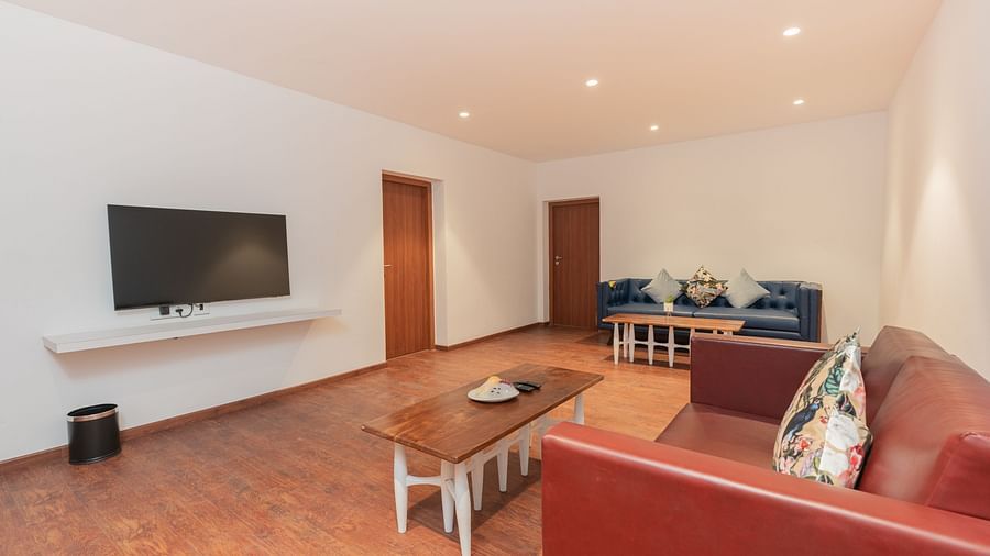 corner view of the entire living room with two couches with a wall mounted tv in front of it in the family villa two bedroom - Darza Resorts