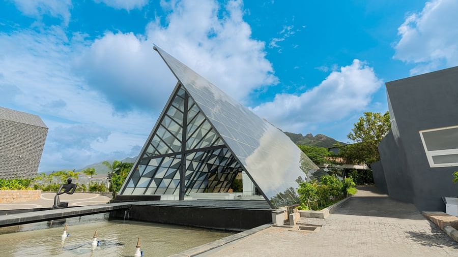 close up image of the exterior of the lobby of Darza Resorts in coimbatore with a fountain pool in front of it