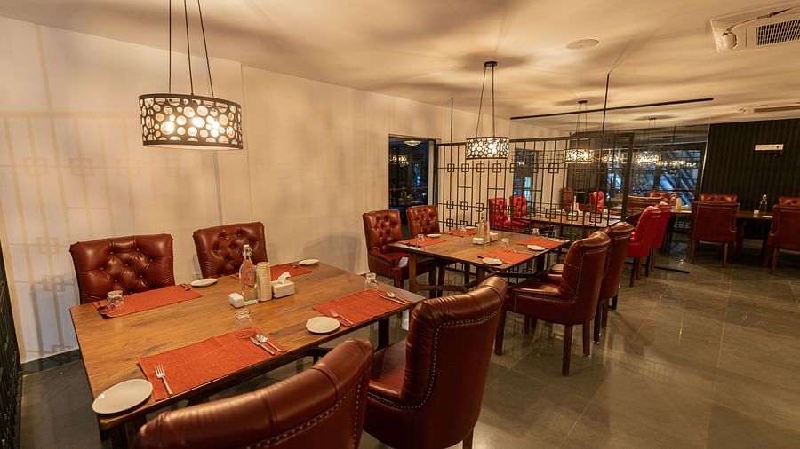 image of a well arranged dining tables lined with four leather chairs inside the mekong restaurant - Darza Resorts