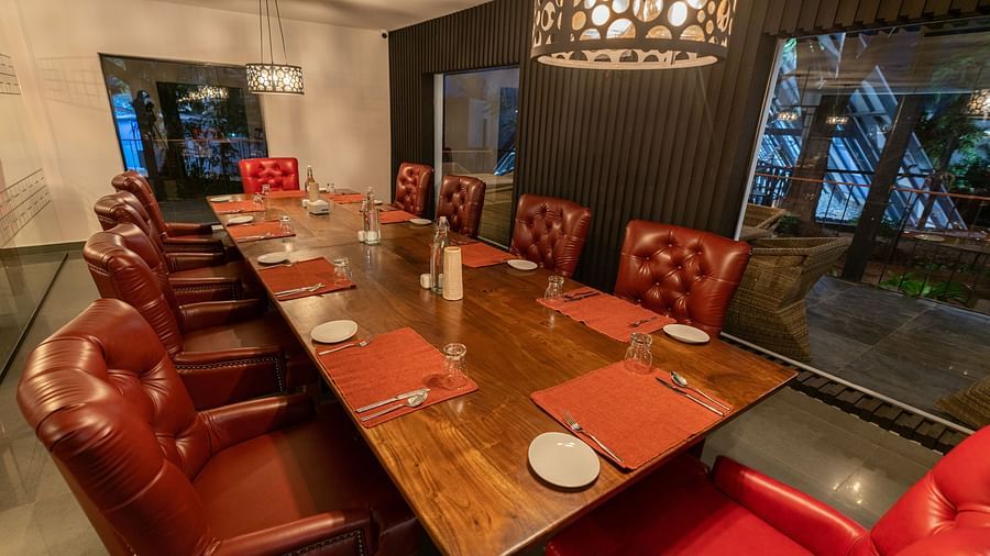 image of a long wooden dining table inside the mekong restaurant lined with brown leather chairs - Darza Resorts