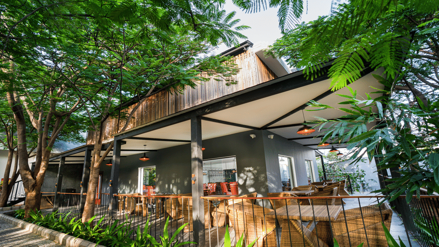 A corner view of the Mekong restaurant, one of the best restaurants in Coimbatore, surrounded by tall lush green plants at Darza Resorts.