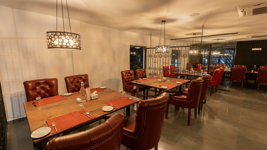A well arranged dining tables lined with four leather chairs inside the mekong restaurant at Darza Resorts