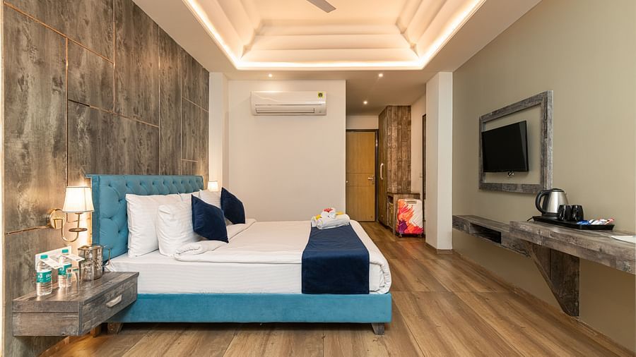 A premium room image with a bed, bed side tables, a flat screen TV, and room amenities like tea and coffee maker - DLS Ganga Bliss, Haridwar
