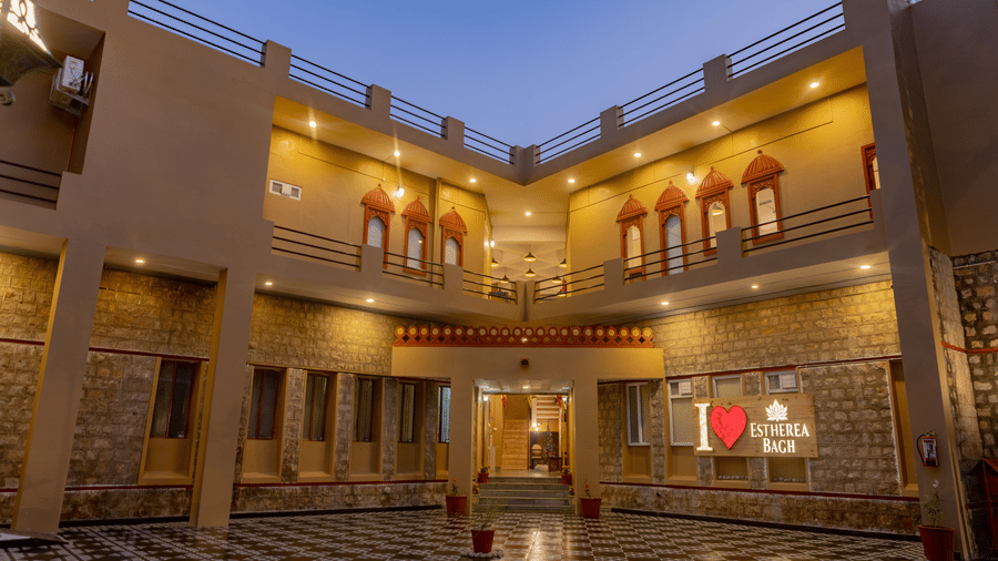 Night view of the illuminated multi-storey main building courtyard at Estherea Bagh, Ranthambore.