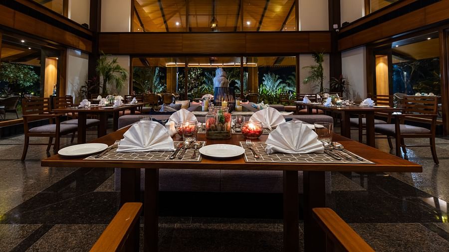 Seating arrangement inside the Restaurant with cutlery on the table in view - Gamyam Resort