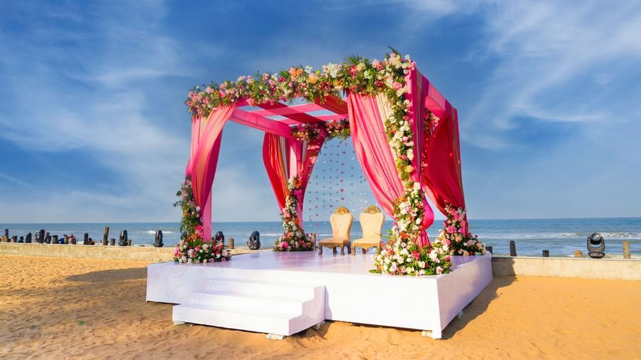 An outdoor stage decorated with pink and flowers featuring blue sky & the sea at the backdrop at Grande Bay Resort & Spa.