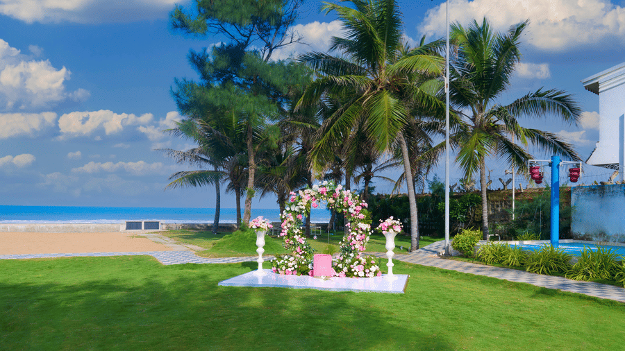 Circular floral decor placed on a lawn near the shoreline with coconut trees - Grande Bay Resort & Spa, Mamallapuram