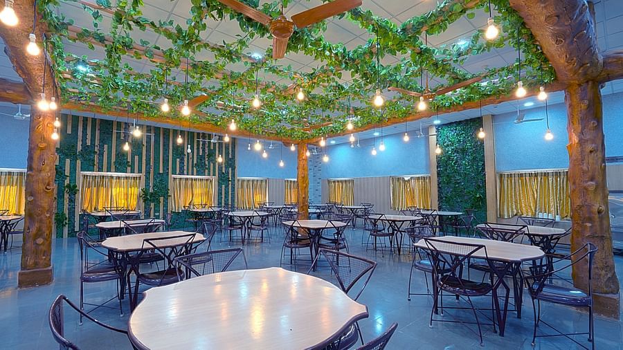 An outdoor dining area decorated with lights strung through the trees, providing a cozy ambiance at Greens Inn - Outdoor Dining Experience in Ramoji Film City.