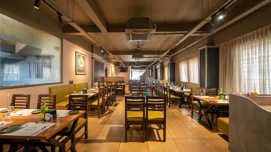Image of a dining area with wooden tables and chairs at Hari Govindas, Siddappa Square.
