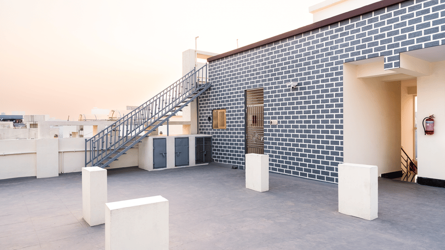 The terrace at Hotel Aurora Bliss, Gachibowli, with several small poles, staircase, and doors.