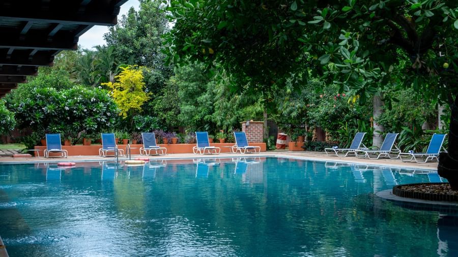 Swimming Pool with a lot of  lawn chairs