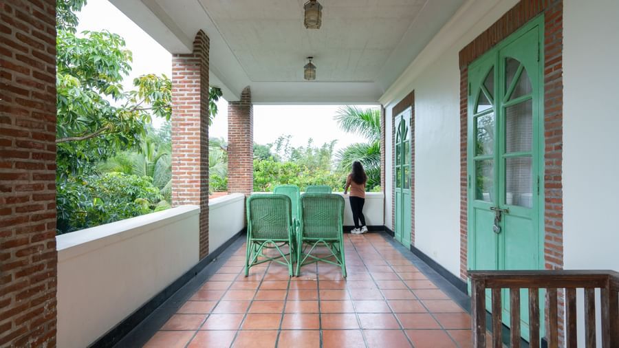 Suite Balcony with two mint green chairs and a door