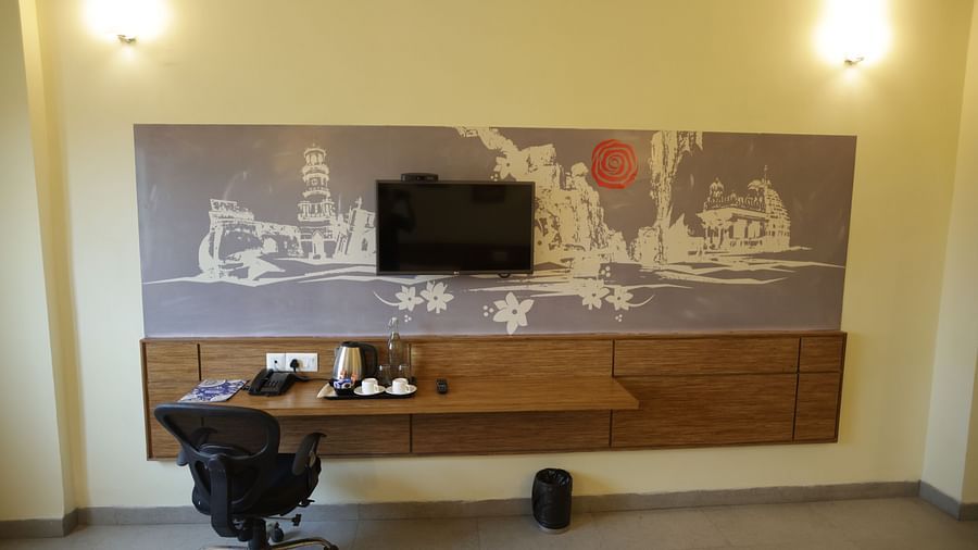 a wall mounted television along with a work desk and an office chair in a room - Max Hotel Jabalpur