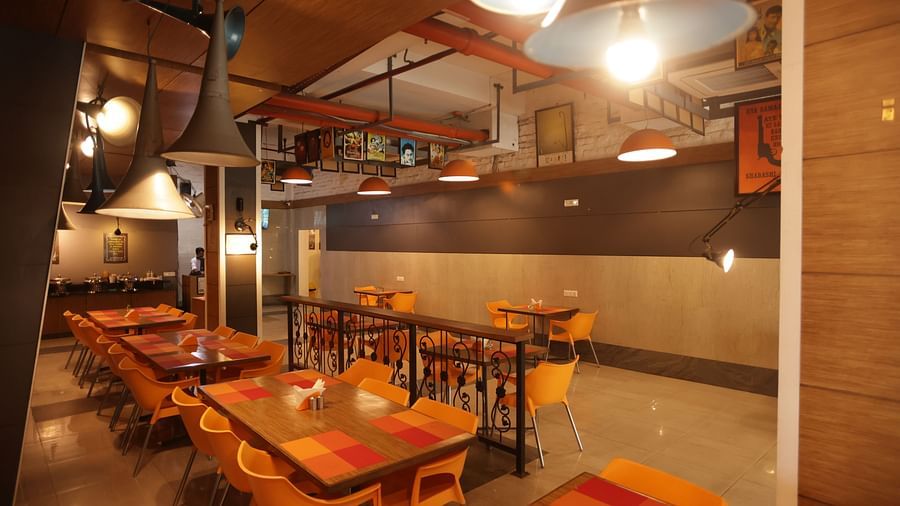 full view image of the dining area with cosy interiors and warm lighting - Max Hotel, Jabalpur