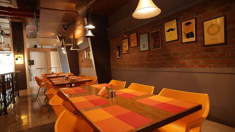 corner view image of the dining area with a warm ceiling light hanging over the table - Max Hotel, Jabalpur