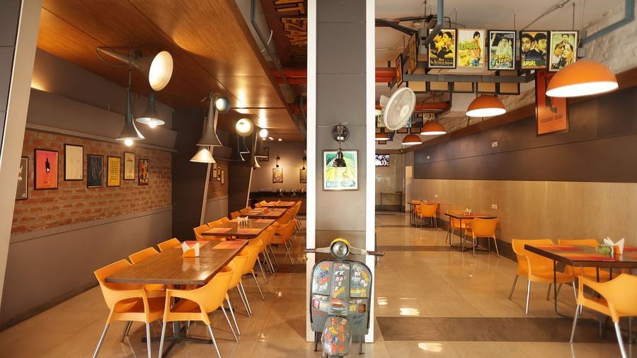 front view image of the dining area with a decorative vintage two wheeler kept in the entrance - Max Hotel, Jabalpur