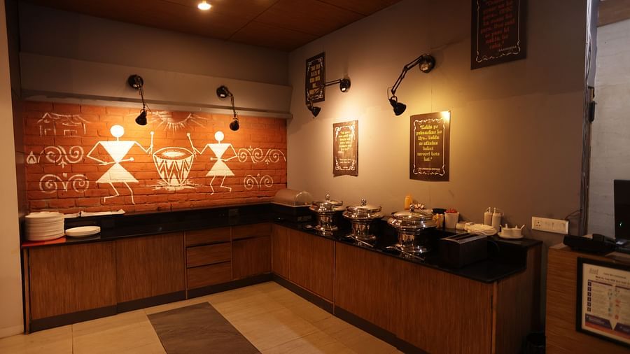 a buffet area in the corner of the restaurant with wall hanging decorative pieces - Max Hotel, Jabalpur