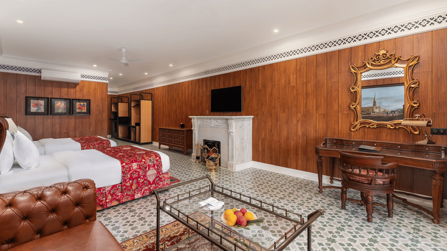 Spacious guest room featuring twin beds, fireplace, and vanity set at Mayfair Manor, Jungpana.
