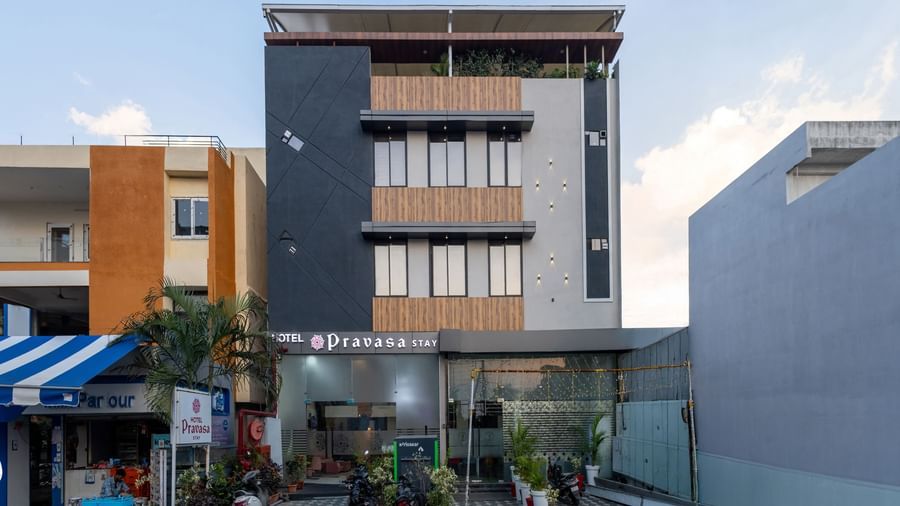 The facade of a modern multi-storey Pravasa Stay Dewas Naka, Indore under the blue sky.