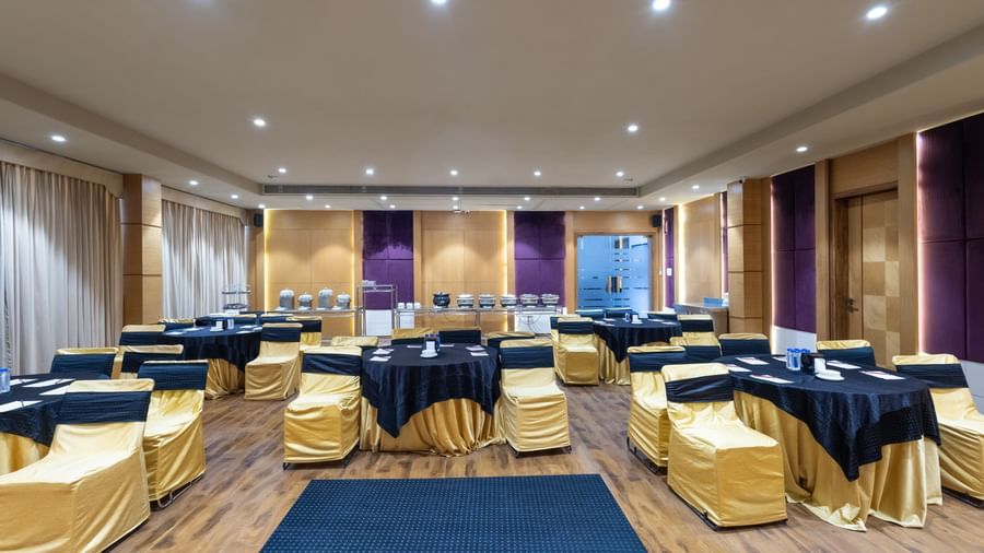 Banquet hall, Iris, with tables in cluster seating arrangment, wooden flooring, seen at Pravasa Stay Vijay Nagar, Indore.