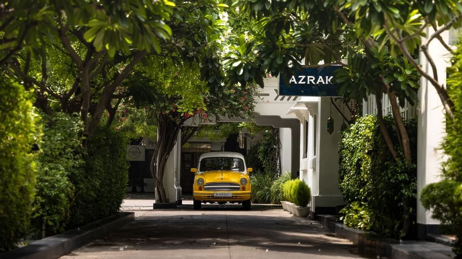A yellow car parked on the front porch of Saraca Hotel, Lucknow