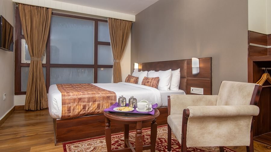 An image of a room with a queen size bed, TV and a chair and a table - Sumitel Vista TV Tower