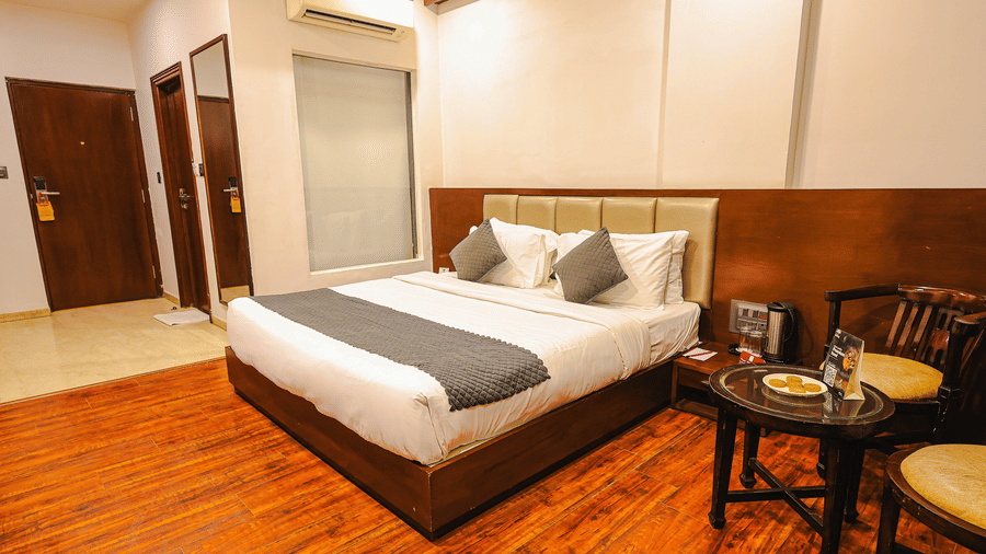Spacious room with wooden flooring, cosy seating and modern décor at TGI Apple Inn, Ajmer Road, Jaipur.