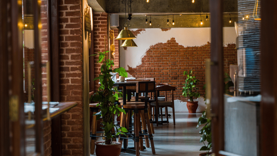 Cosy restaurant interior at The Nanee, Bhaktapur, Nepal. wooden tables and potted plants create an inviting dining atmosphere.