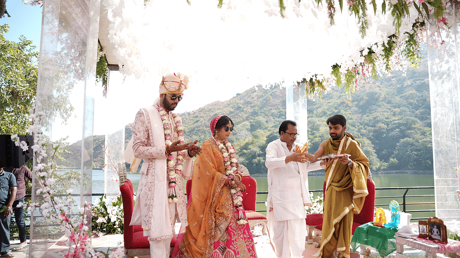 Bride and groom in traditional attire, walking with family - Via Lakhela Resort & Spa