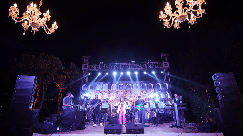 Live musical performance on an illuminated stage with chandeliers at Heritage Village Resorts & Spa, Manesar during an evening wedding.