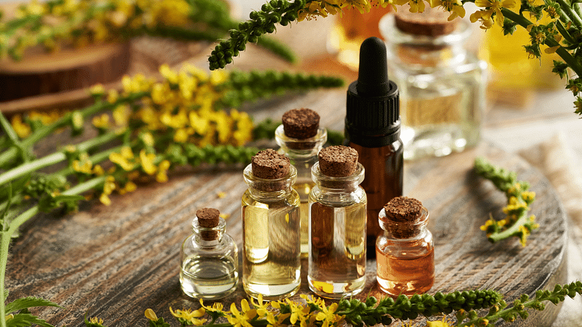 A close up image of essential natural oils and other aromatics beautifully arranged on a wooden table.