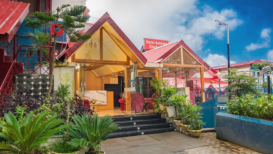 An image featuring tents with plants kept next to their entrances under blue sky