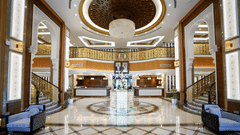 overview of the Lobby with staircase on either side leading to the top floors - La Maison Hotel, Doha