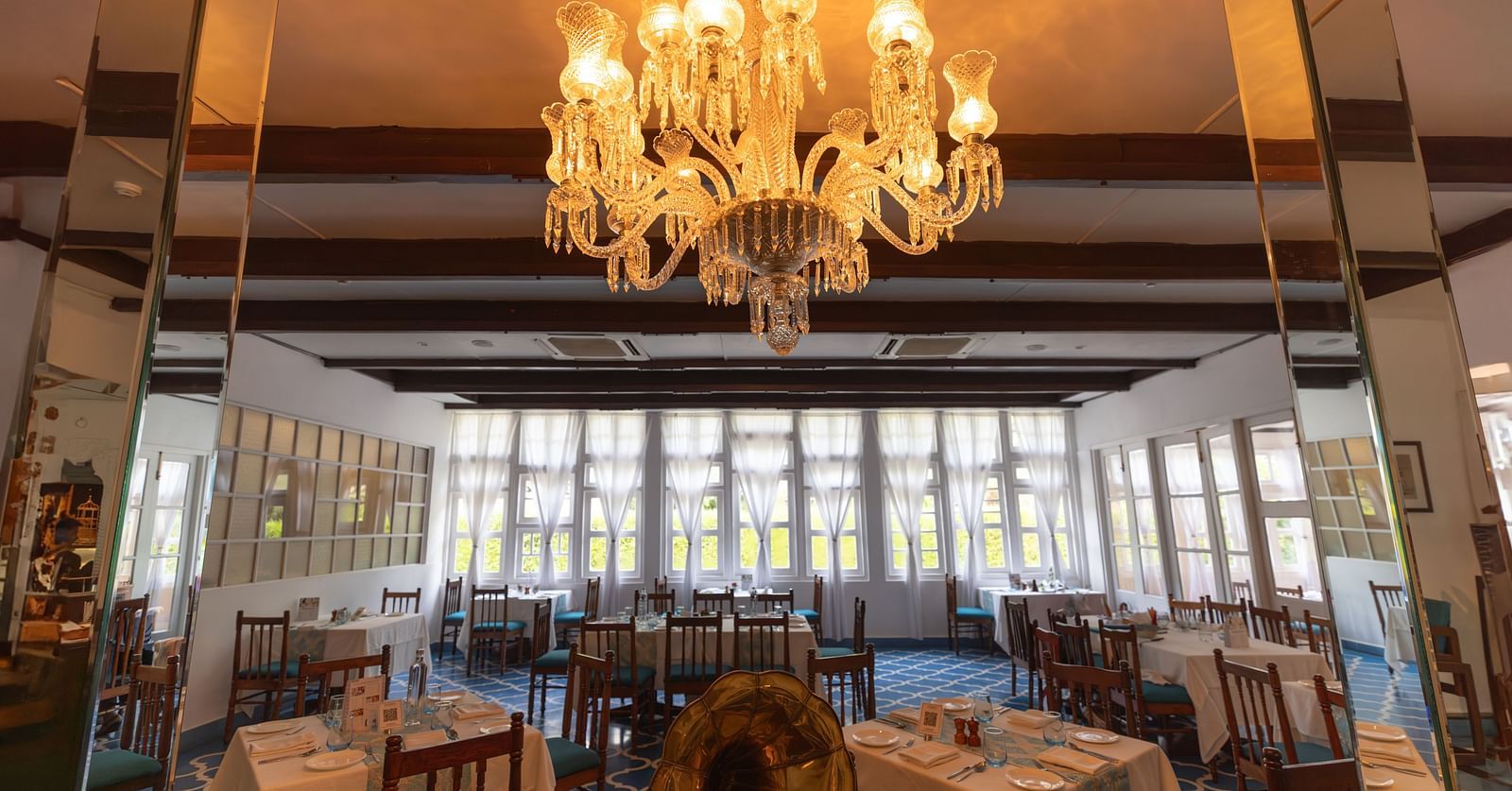 Interiors of Azrak Restaurant at Saraca Hotel, Lucknow with dining arrangement placed in front of large windows