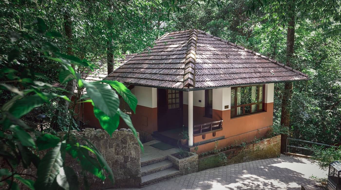 An exterior view of a villa nestled in greenery | Vythiri Resort. Wayanad