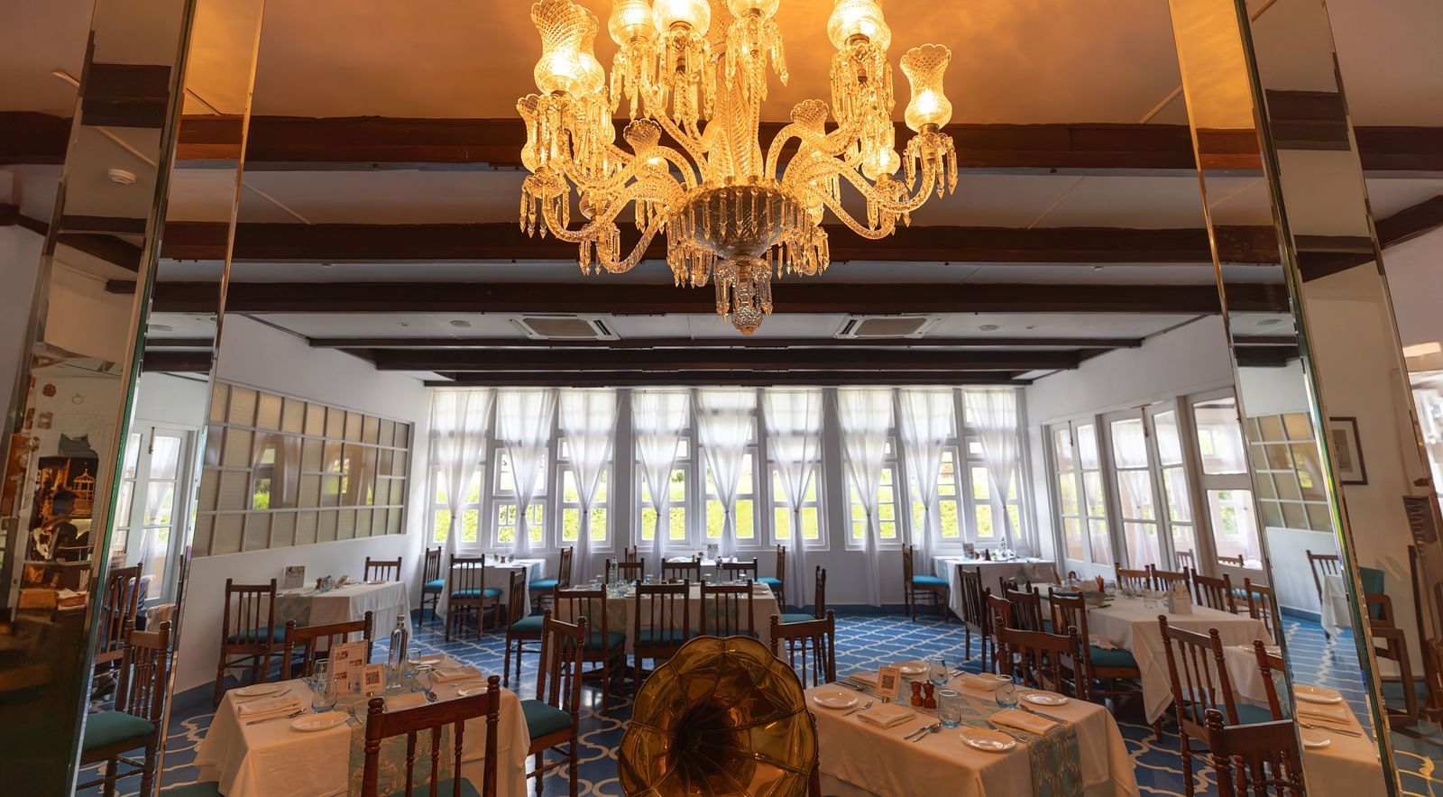 Interiors of Azrak Restaurant at Saraca Hotel, Lucknow with dining arrangement placed in front of large windows