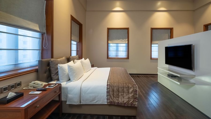 side view of the bed with a television in front at the Premier Club Room at Kenilworth Hotel, Kolkata