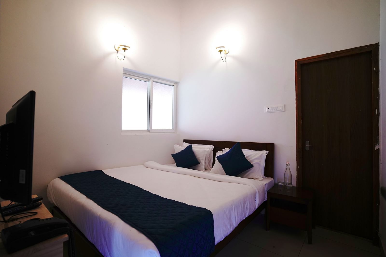 Ravishing Retreat Harisandra - The bedding and interiors of a room at Ravishing Retreat featuring a double bed in front of a TV mounted on the wall