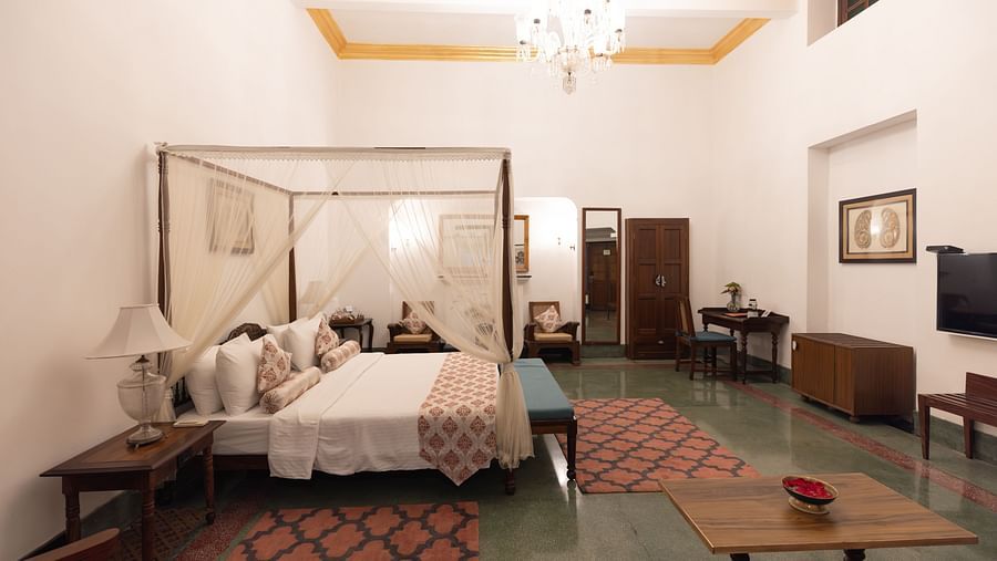 Imperial Suite at Saraca Hotel, Lucknow with a double bed placed in the centre of the room, surrounded by carpets and cabinets