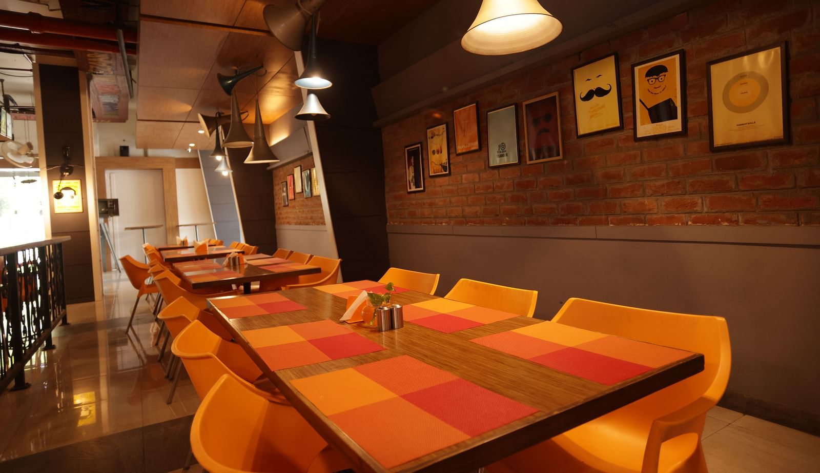 corner view image of the dining area with a warm ceiling light hanging over the table - Max Hotel, Jabalpur