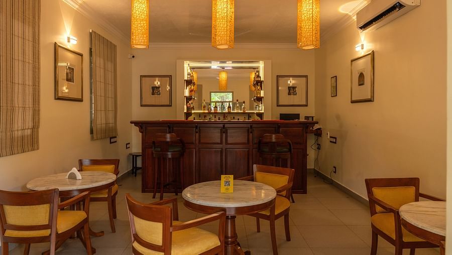 Restaurant seating area with tables and chairs and lamps. 