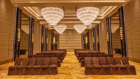 Banquet hall with theatre-style seating arrangement and majestic chandeliers - Grand Madurai by GRT Hotels