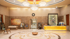 A hotel lobby with a reception desk and comfortable seating.