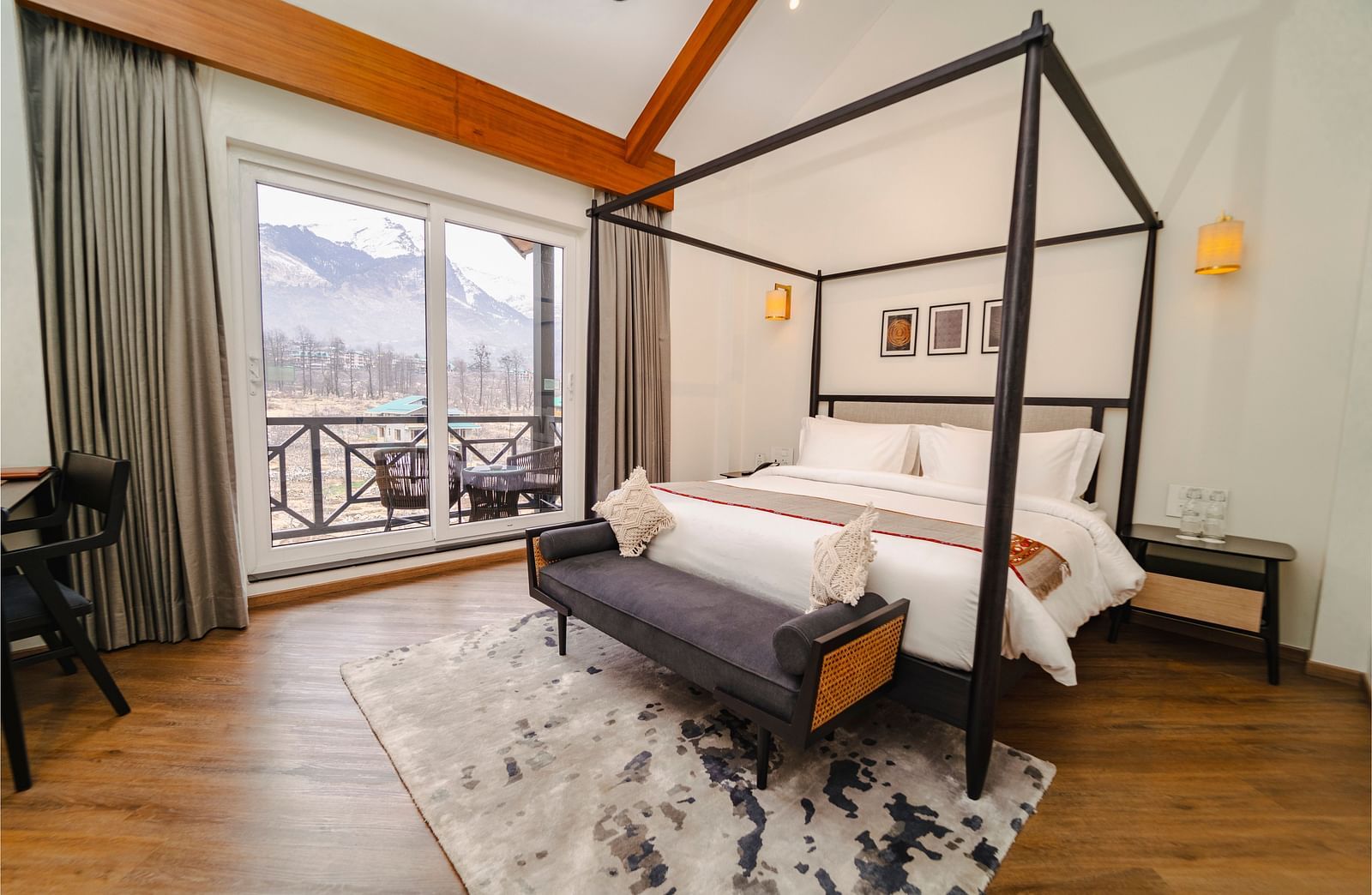 Bedroom with a four-poster bed, balcony, and mountain view at Nivasana Manali.
